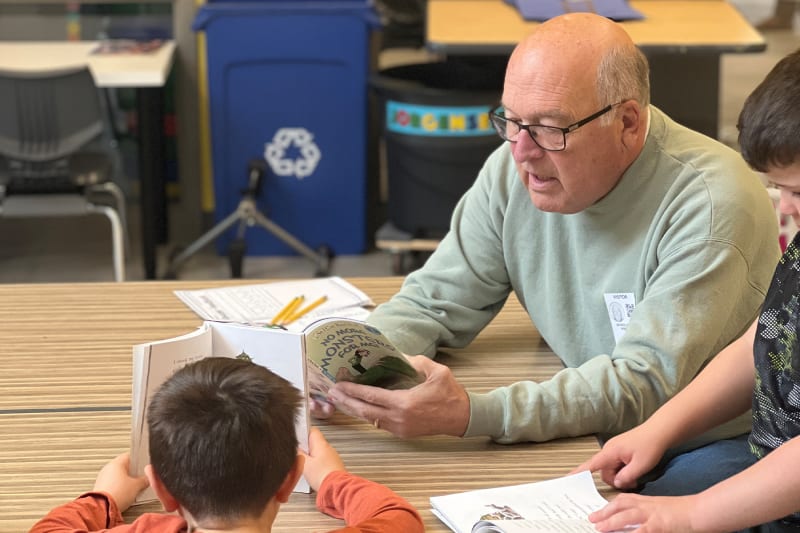 A volunteer reads to students as part of an elementary school literacy program.