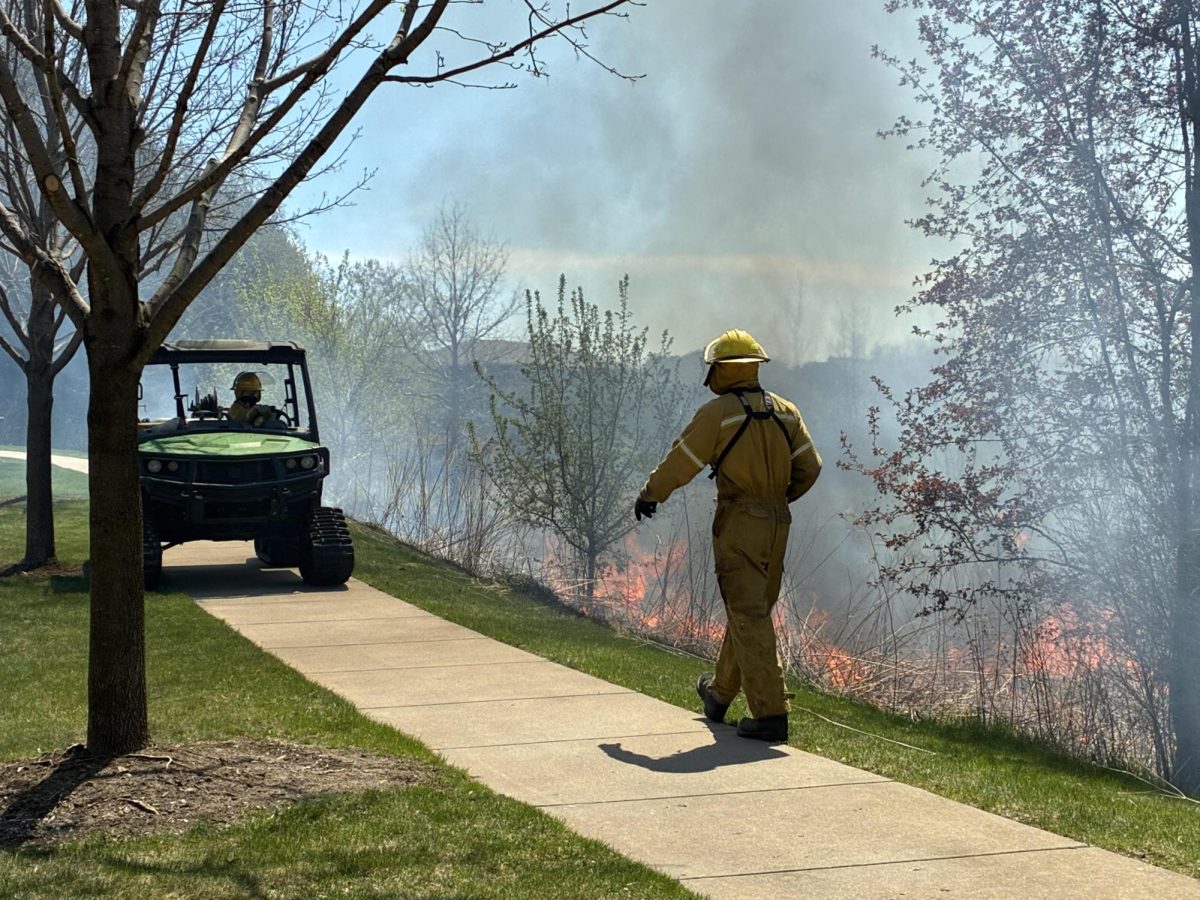 Resource managers Tom Kohm and Ella Stone keep an eye on a controlled burn at Bailey’s Arbor Park Tuesday.