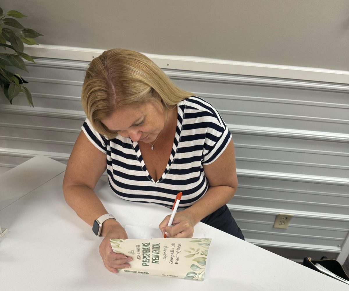 Woodbury author Ann Schreiber signs one of her books at a recent appearance. Her first novel, "Emily's Next Chapter," is being released this week. Photo: Contributed.