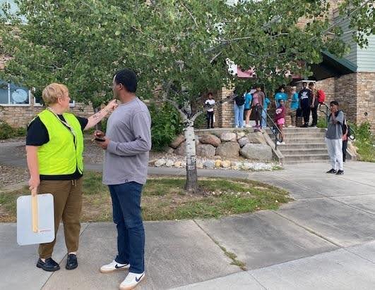 Math and Science Academy’s student drop-off crossing guard April McClernan, left, chats with a visitor while directing traffic Tuesday morning.