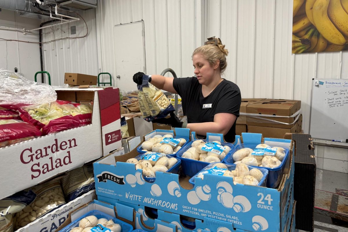Kate, a volunteer at Open Cupboard, organizing food to place into their emergency boxes.