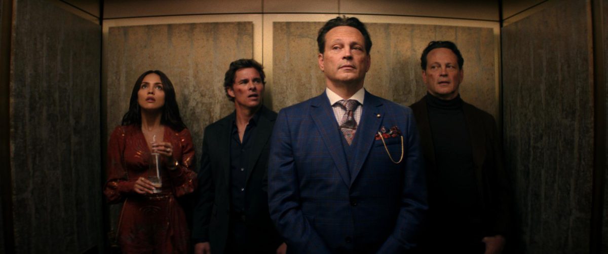 A woman and three men stand next to each other in an elevator.