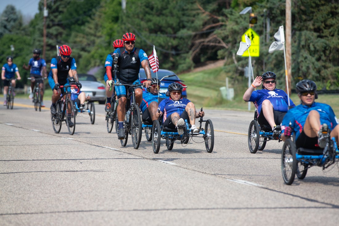 Mike Owens (pictured with the red helmet and prosthetic arm) is a Marine veteran who served multiple combat deployments and lost his right arm in Iraq in 2005. (Credit/Joey Dickinson/Wounded Warrior Project).
